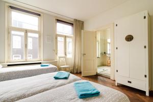 a bedroom with two beds and two windows at Marnix360apartments Classic in Amsterdam