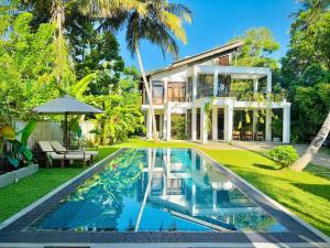 an exterior view of a house with a swimming pool at Villa Ema in Galle