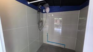 a shower in a bathroom with white tiles at OneSeasonFarm Chiangsaen in Chiang Saen +40 photos