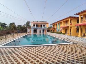 an empty swimming pool in front of a building at Chuti Beach Resort in Mandarmoni