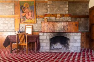 a room with a fireplace with a table and a chair at Timberwolves Vintage Manali in Manāli