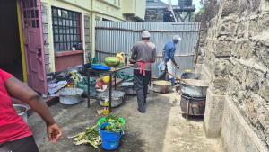two men standing in a courtyard with pots and pans at Kiwis home in Nakuru