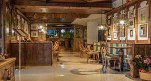 ein Restaurant mit Holzwänden, Tischen und Stühlen in der Unterkunft Hotel Ai Pini in Vigo di Fassa