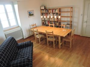 uma sala de jantar com uma mesa de madeira e cadeiras em VINITA Chambres d'hôtes em Boncourt