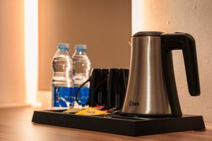 a kettle on a counter with two bottles of water at Jarzez Inn Hotel Azaiba فندق جرزيز إن العذيبة in Muscat