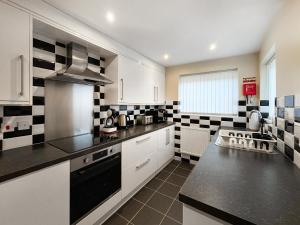 a kitchen with black and white tiles on the wall at Pilots Loft in Menai Bridge