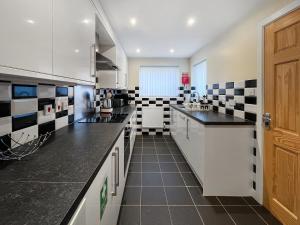 a kitchen with black and white tiles on the wall at Pilots Loft in Menai Bridge
