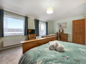 a bedroom with a bed with towels on it at Pilots Loft in Menai Bridge +12 photos