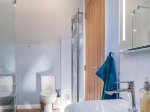 a bathroom with a white toilet and a sink at The Old Dairy in Nether Broughton +6 photos