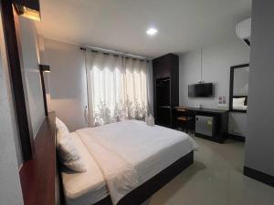 a bedroom with a bed and a desk and a television at Nakarin Hotel in Amnat Charoen