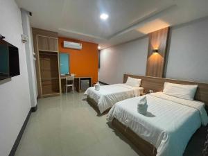 a hotel room with two beds and a television at Nakarin Hotel in Amnat Charoen +22 photos