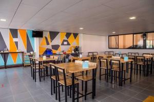 a restaurant with wooden tables and chairs in a room at Nakarin Hotel in Amnat Charoen