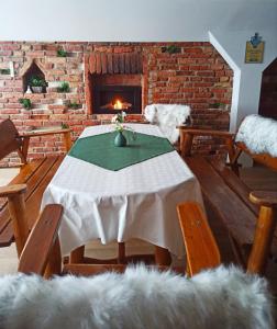 a dining room with a table and a fireplace at Agroturystyka Pod Małą Górą in Łopuszna