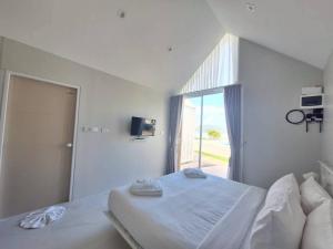 a white bedroom with a bed and a large window at Miami Seaview in Ban Pak Ba Ra +18 photos