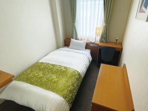a hotel room with a bed and a desk at Hotel Hiroshima Sunplaza in Hiroshima +15 photos