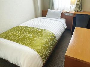 a hotel room with two beds and a desk at Hotel Hiroshima Sunplaza in Hiroshima