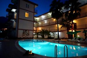a swimming pool in front of a building at night at Aybel İnn Hotel in Beldibi +19 photos