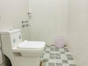 a white toilet in a bathroom with a tiled floor at Grace villa in Mandrem +8 photos