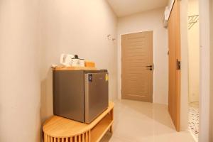 a small refrigerator in a room with a door at Miami Seaview in Ban Pak Ba Ra