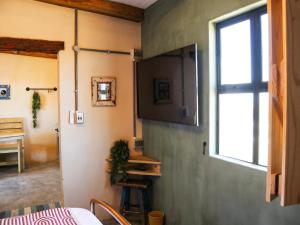 a room with a tv on a wall with a window at Die Stalle by Chickania in Jacobs Bay