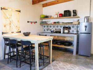 a kitchen with a wooden table and a refrigerator at Die Stalle by Chickania in Jacobs Bay