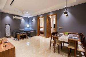 a living room with a dining table and a couch at Hotel Xotic Avenue in Gurgaon