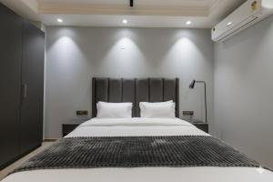 a bedroom with a large bed with a black headboard at Hotel Xotic Avenue in Gurgaon