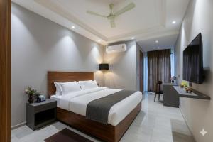 a hotel room with a bed and a desk at Hotel Xotic Avenue in Gurgaon