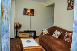 a living room with a couch and a tv at Kajole Homestay in Kakamega