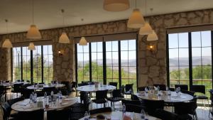 una sala da pranzo con tavoli, sedie e finestre di Mountain Breeze Lodge & Resort ad Al-Salṭ