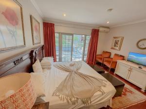 a bedroom with a bed and a living room at Amoris Guesthouse - Waterkloof ridge in Pretoria