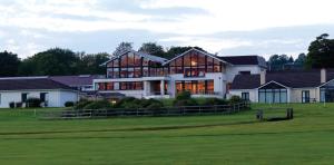 a large house on a golf course with a green at Castlerosse Park Resort Holiday Homes in Killarney