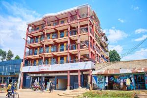a tall red building with people walking in front of it at Kajole Homestay in Kakamega