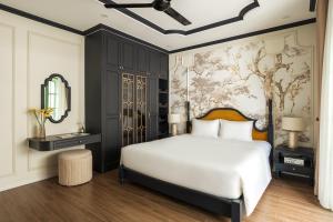 a bedroom with a white bed and a wall mural at Villa Vanda Phu Quoc in Phú Quốc