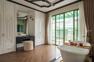 a bathroom with a tub and a sink and a mirror at Villa Vanda Phu Quoc in Phú Quốc +65 photos