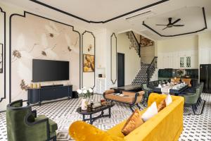 a living room with couches and a flat screen tv at Villa Vanda Phu Quoc in Phú Quốc