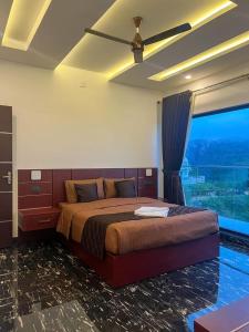 a bedroom with a large bed with a large window at ADAM'S FORT by Dell'amore Havn in Vagamon