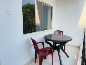 a black table and two chairs and a window at Grace villa in Mandrem