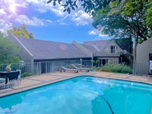 a swimming pool in front of a house at Amoris Guesthouse - Waterkloof ridge in Pretoria