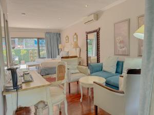 a living room with a blue couch and chairs at Amoris Guesthouse - Waterkloof ridge in Pretoria