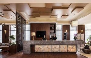 a lobby with two people standing at a counter at SSAW Boutique Hotel Dexin Mogan Mountain in Deqing