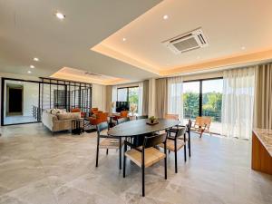 a dining room and living room with a table and chairs at Rivendale in Ban Gaeng Cho