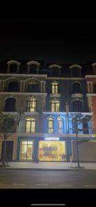 a tall building with a store in front of it at Kapás Hotel in Hai Phong
