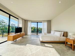a bedroom with a bed and a tv and windows at Rivendale in Ban Gaeng Cho
