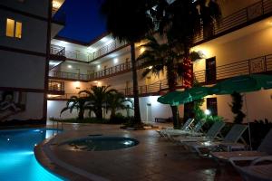 a hotel with a swimming pool with chairs and umbrellas at Aybel İnn Hotel in Beldibi