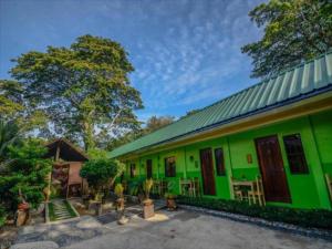 a green building with a green roof at OYO 622 Butterfly Totem Guesthouse in Puerto Princesa City