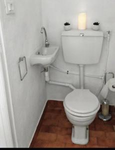 a white bathroom with a toilet and a sink at Casa Dolce Vita in Pigna