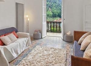 a living room with a couch and a large window at Casa Dolce Vita in Pigna