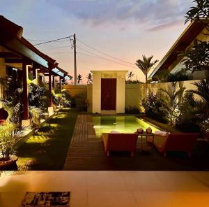 a backyard with a pool and a house at Parama Swaha Villa Near Canggu in Munggu