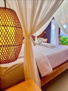 a bedroom with a bed with curtains and a window at Parama Swaha Villa Near Canggu in Munggu